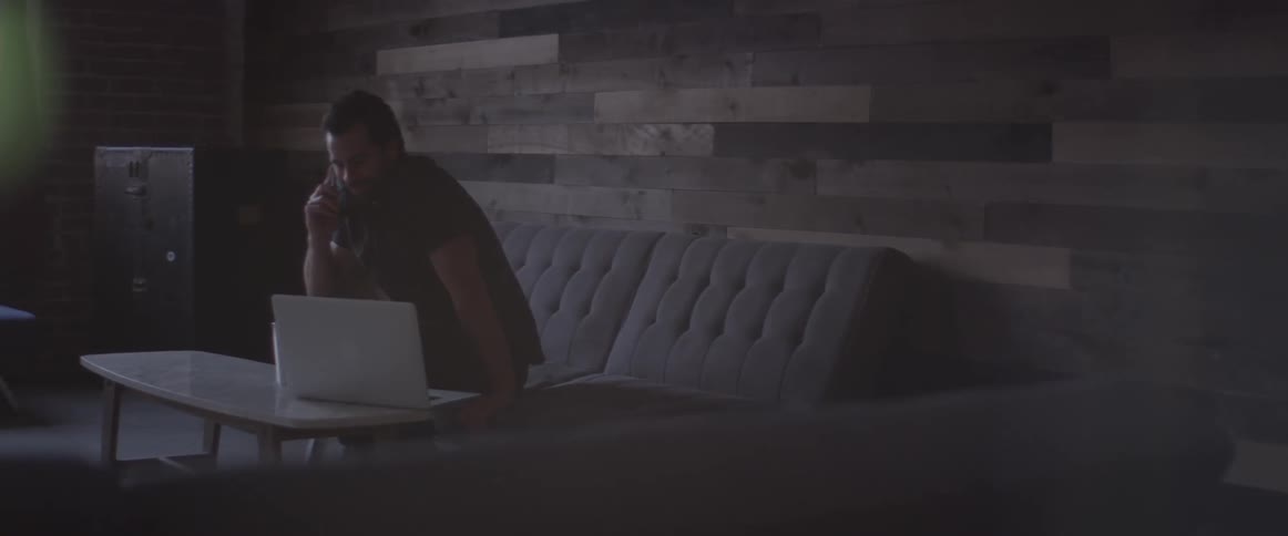 Man Working On Laptop And On The Phone