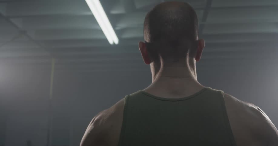 Back of man wearing a tank top in a gym