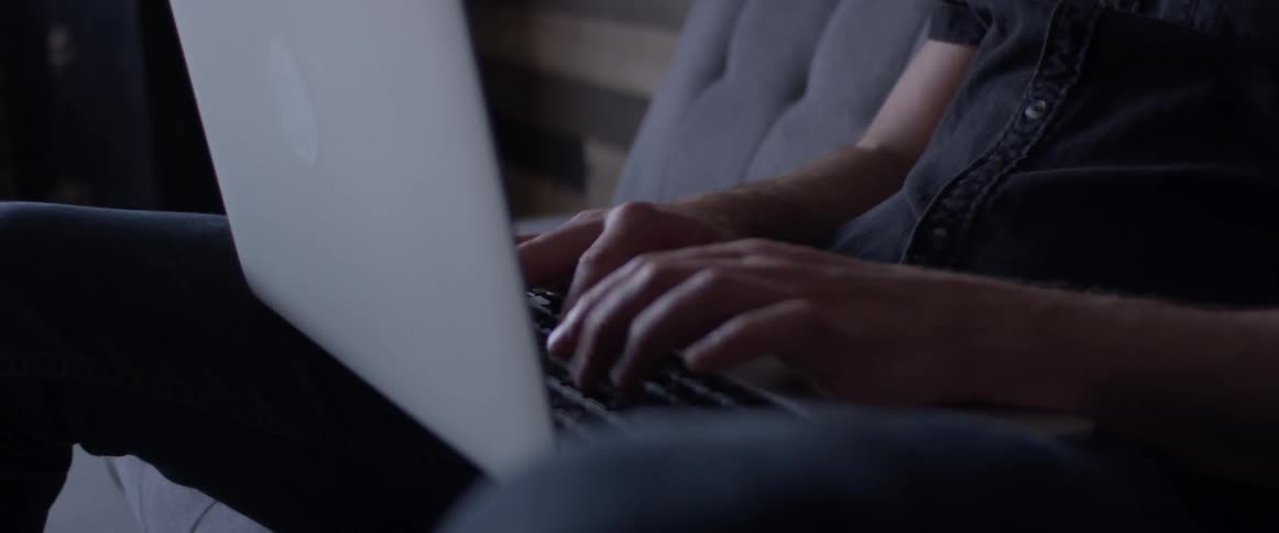 Person sits in a chair typing on a laptop