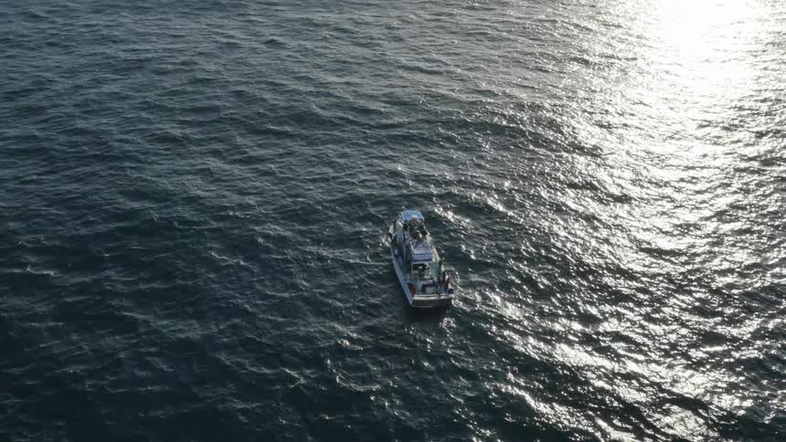 A boat sitting on calm water in the ocean