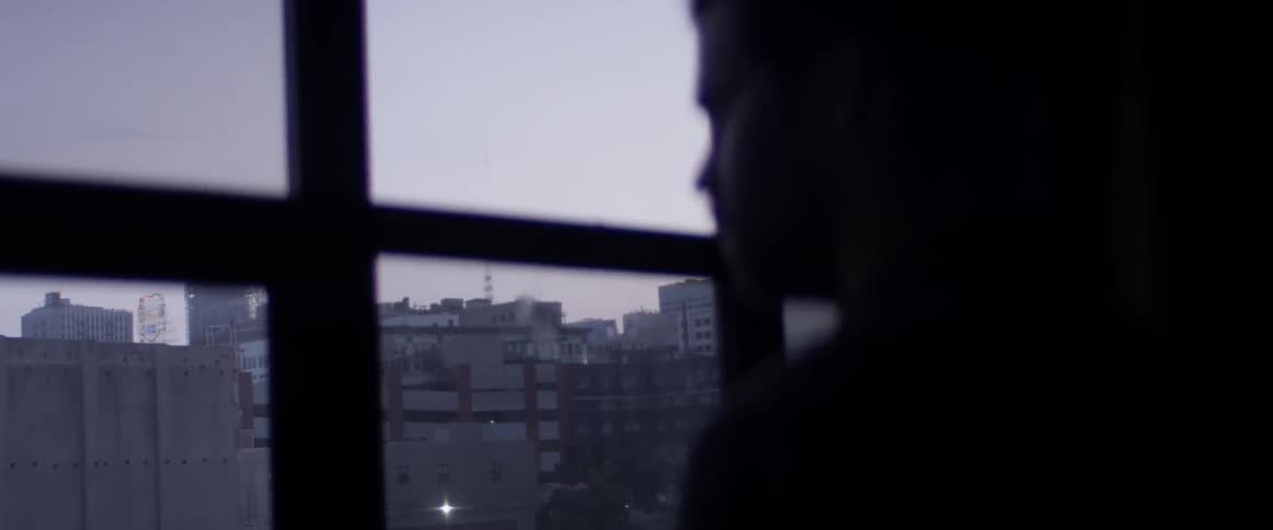 A person looking out a window onto a city