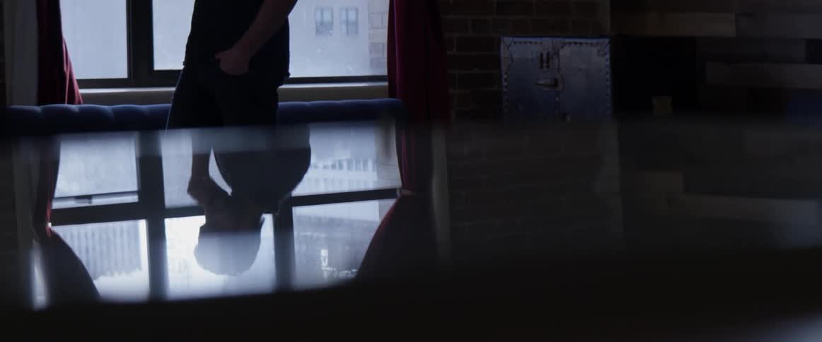 A reflection in the table of a man walking and talking on the phone