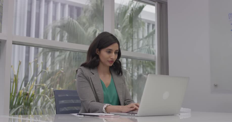 A woman typing on a computer at a desk