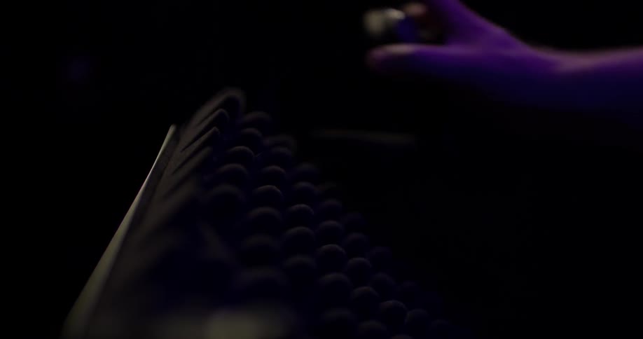 A person grabbing headphones off a stand