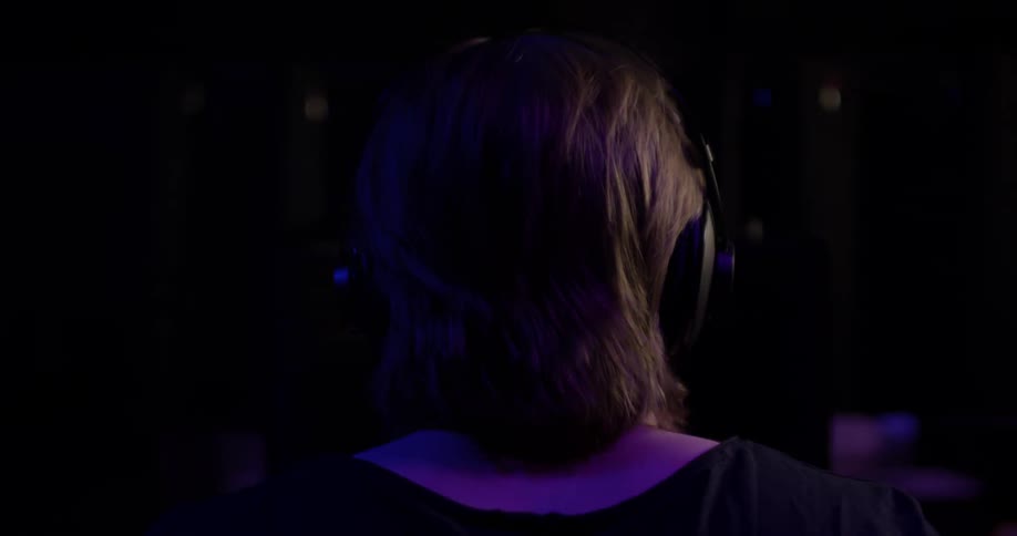 A man putting on headphones in a studio