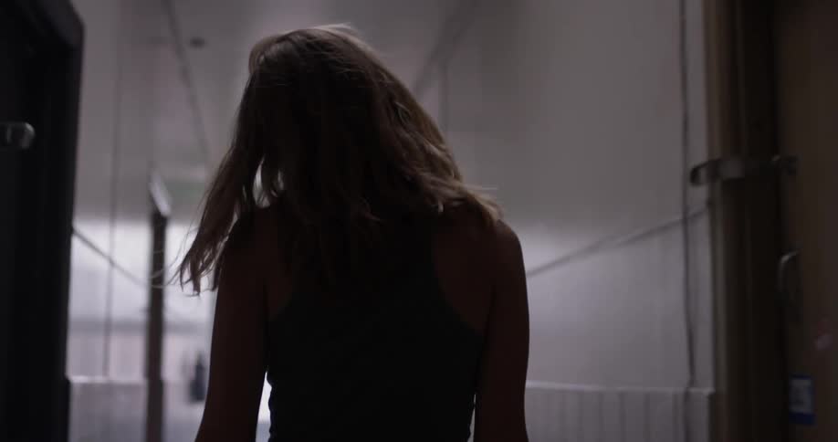Woman walking down a hallway at school
