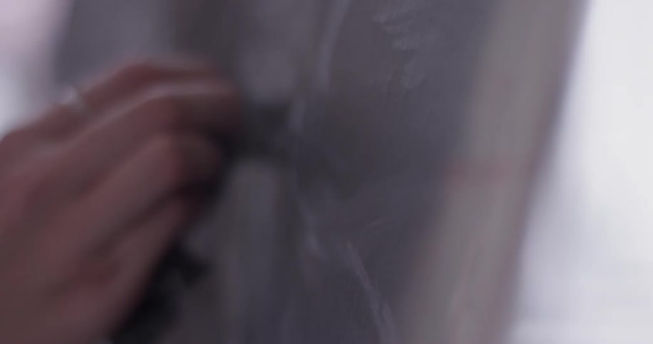A person using charcoal on a canvas