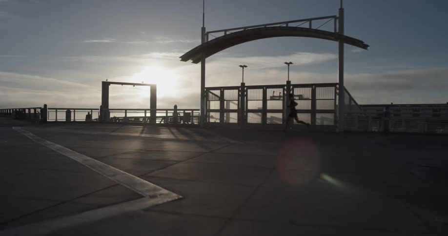 A man is jogging while the sun is setting
