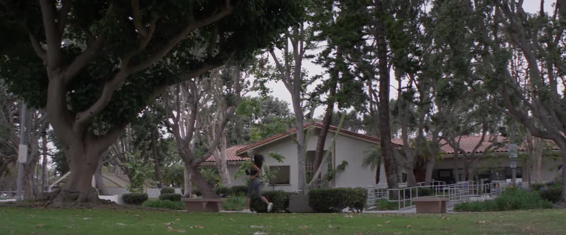Woman runs on sidewalk in the suburbs