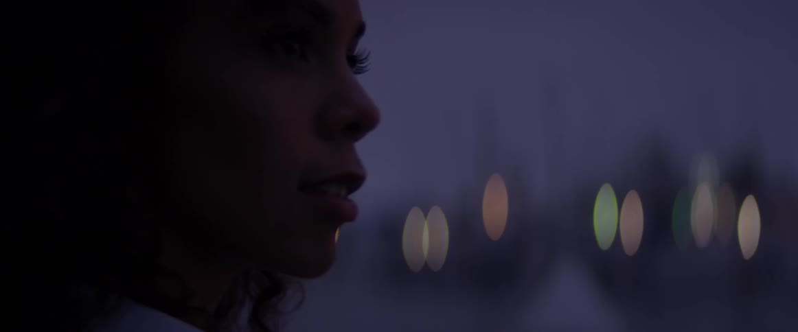 Woman stands outside in the city at night