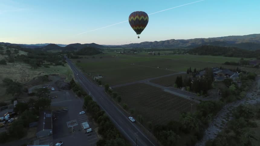 A hot air balloon floating over a rural area
