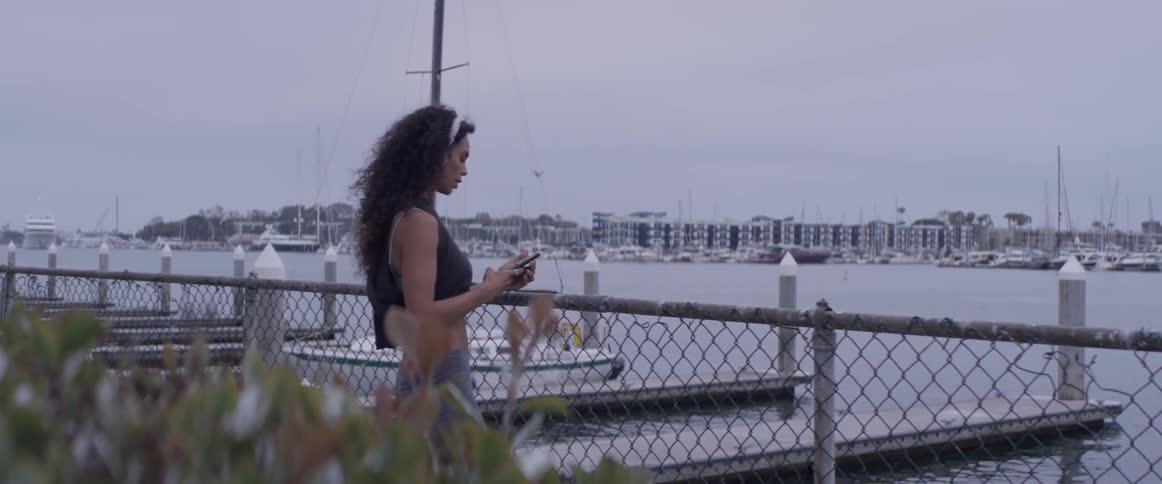 A woman running around outside next to some water