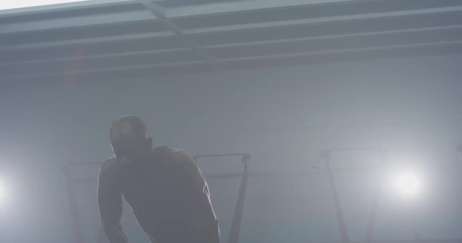 Man stands in a brightly lit room with his hands on his head