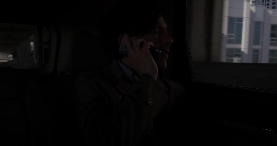 A man talking on a cell phone while riding in a car