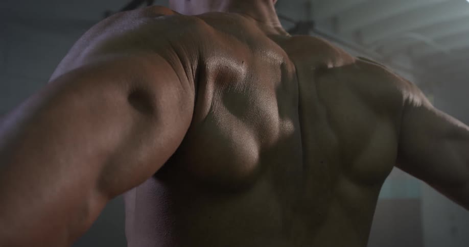 A man flexing his arms at the gym
