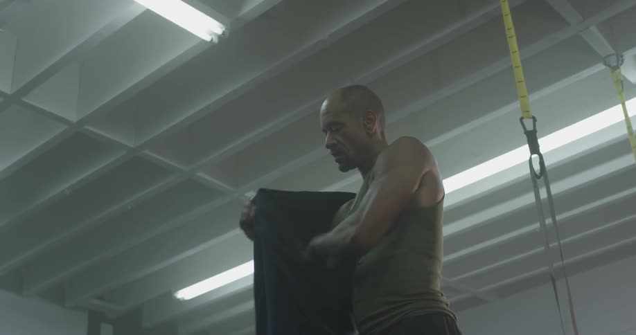 A man puts on a sweatshirt