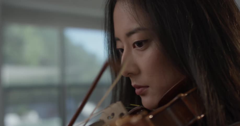 Closeup of a woman playing a violin with enthusiasm