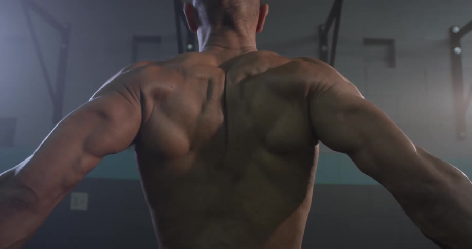 A muscular man shakes out his muscles then stretches