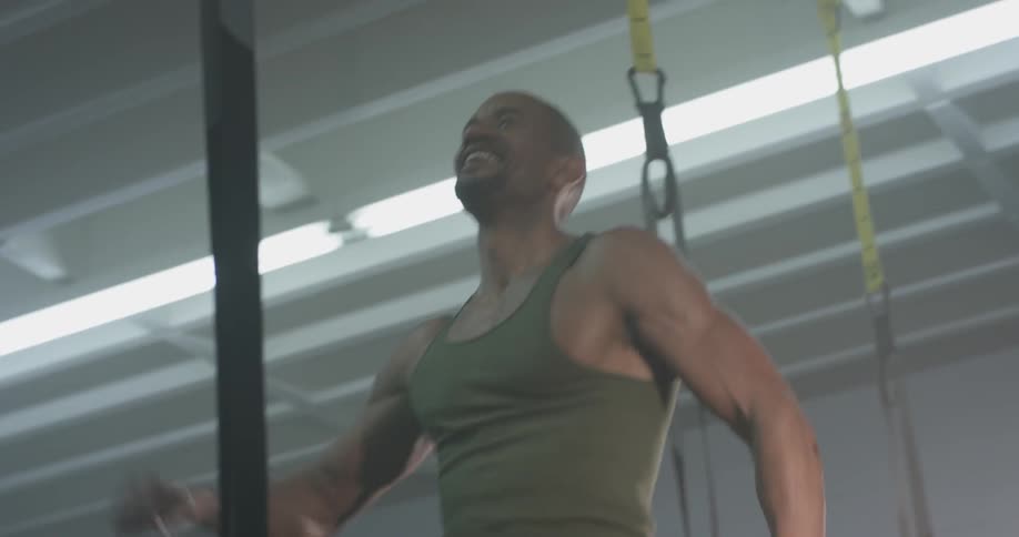 A man clapping his hands jumping up and down at a gym