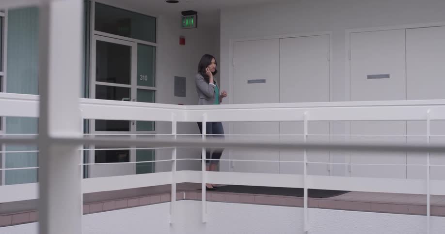 A woman talking on her phone on a balcony