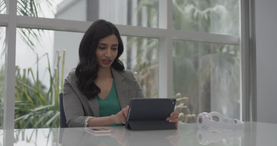 A woman typing on a tablet in an office