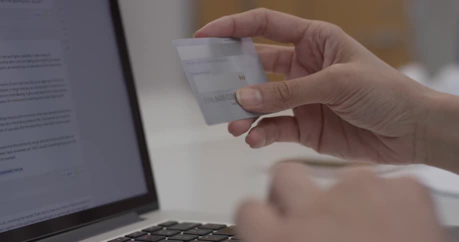 A person entering credit card details into a laptop