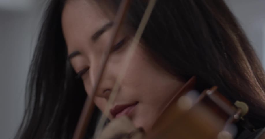Woman plays a violin and closes her eyes