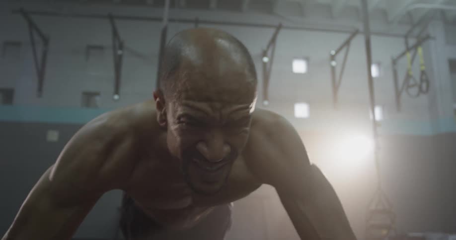 A man in a gym stretching on straps