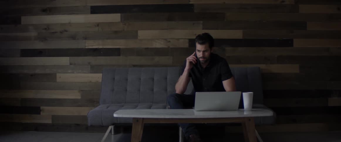 A man sitting on a couch with a laptop