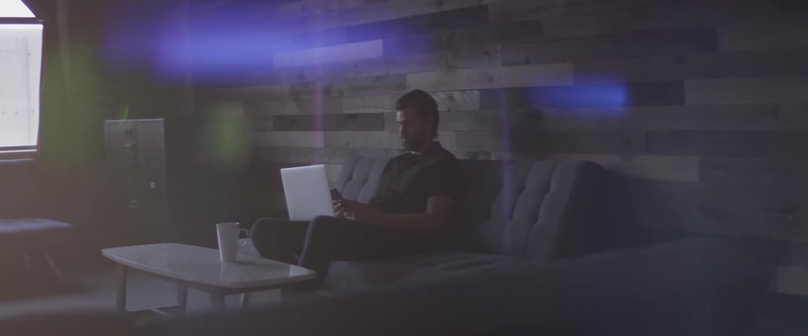Man Working On Laptop And On The Phone