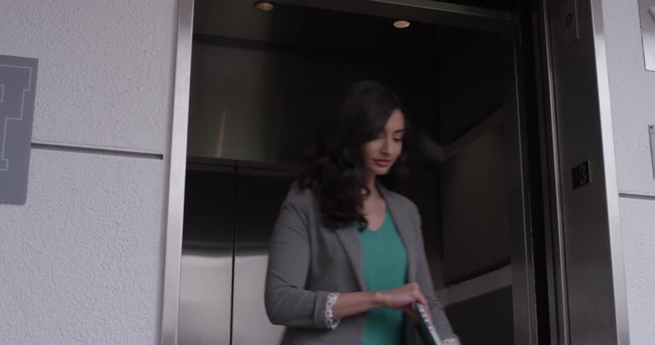 Elevator doors opening up so a woman can walk out