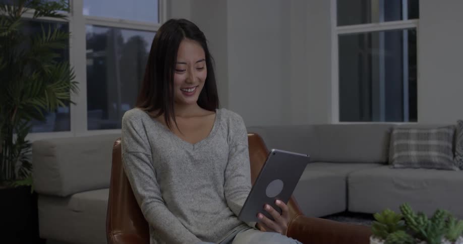 A woman looking at a tablet and talking