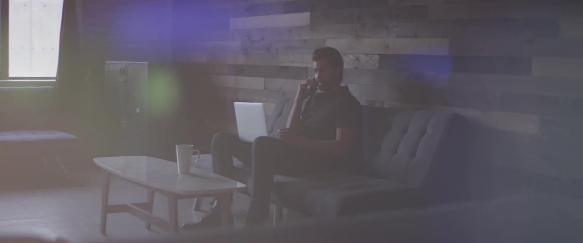Man Working On Laptop And On The Phone