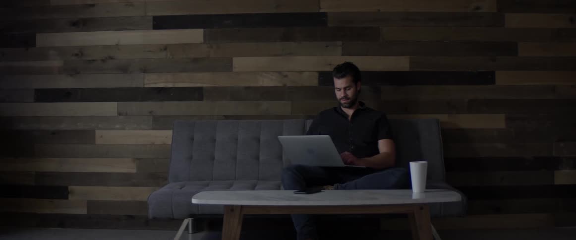 Man Working On Laptop And On The Phone