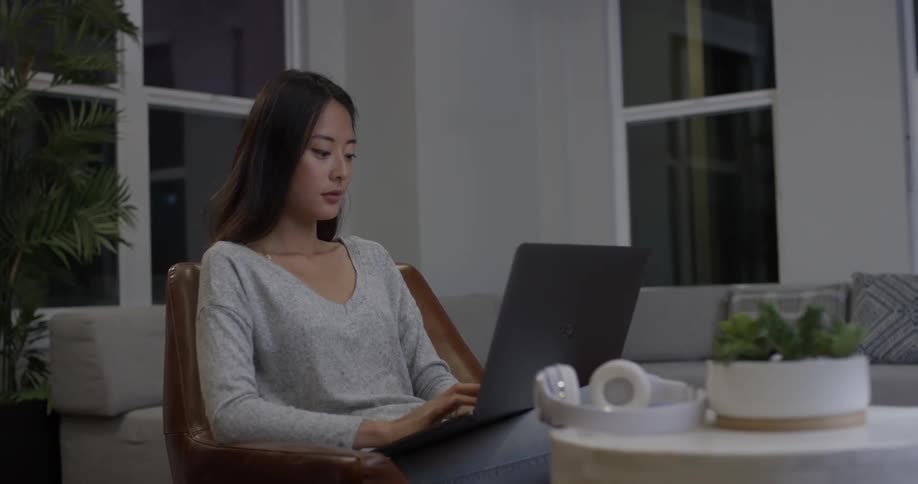 A woman is typing on a laptop