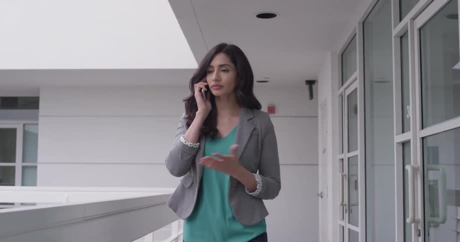 A woman walks down a pathway talking on the phone