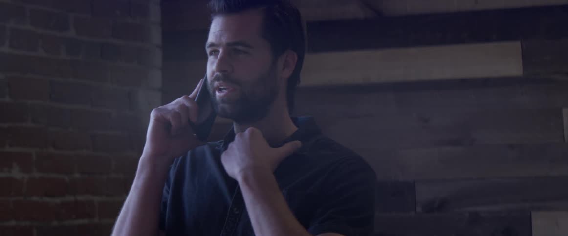 A person talking on a cell phone looking out a window