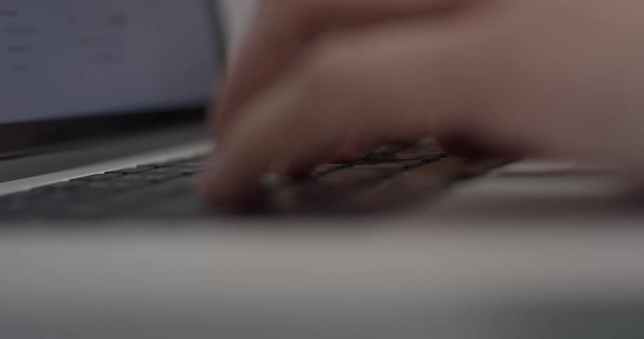 A person typing on a laptop keyboard