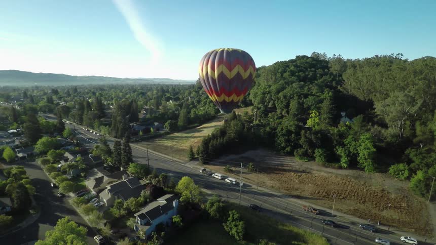 A hot air balloon floating over a residential area