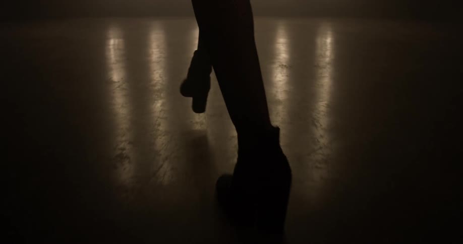 Woman walking onto a stage in front of lights