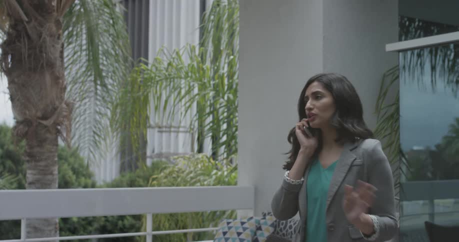 Woman near railing talks on phone and gestures