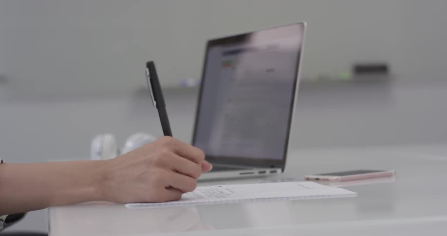 A person writing down notes on a piece of paper