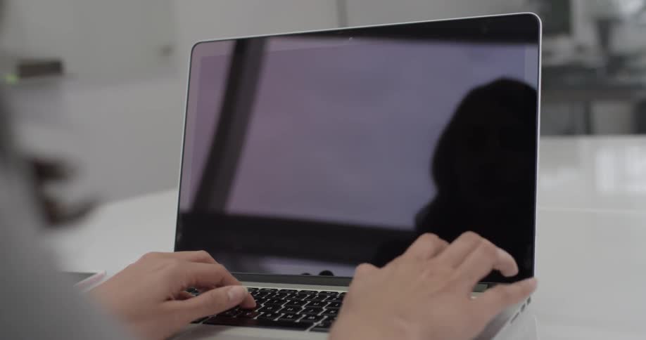 Woman typing on a laptop in an office