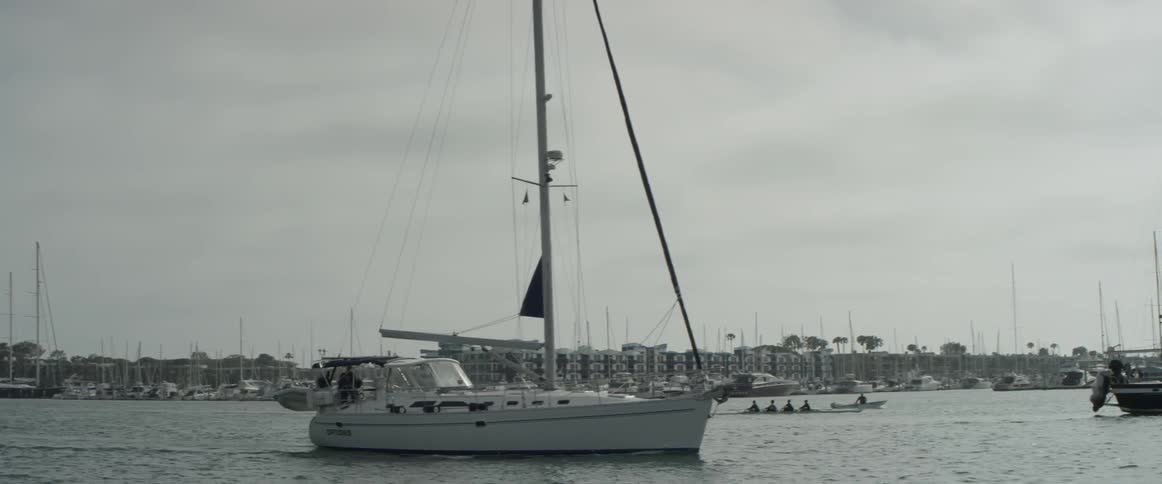 A boat that is sailing on some water near a city