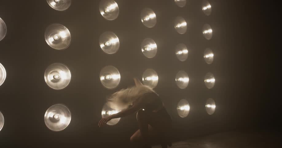 Woman in lingerie dancing in front of lights