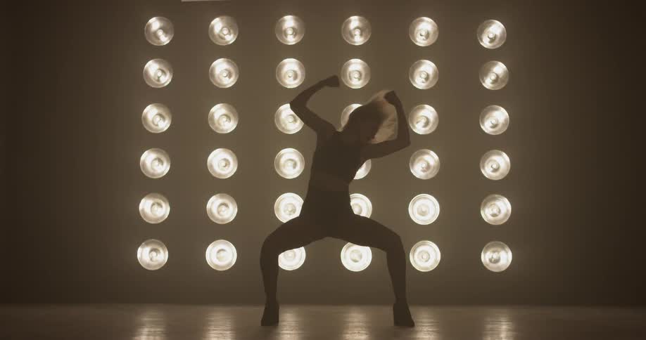 A woman dancing on a stage with a lot of lights