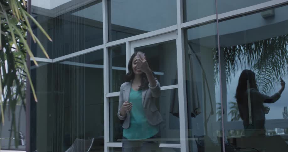 A woman texting on a phone outside a building