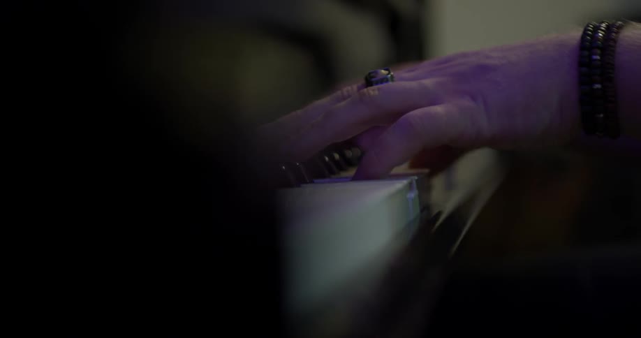 A person playing the piano with bracelets on