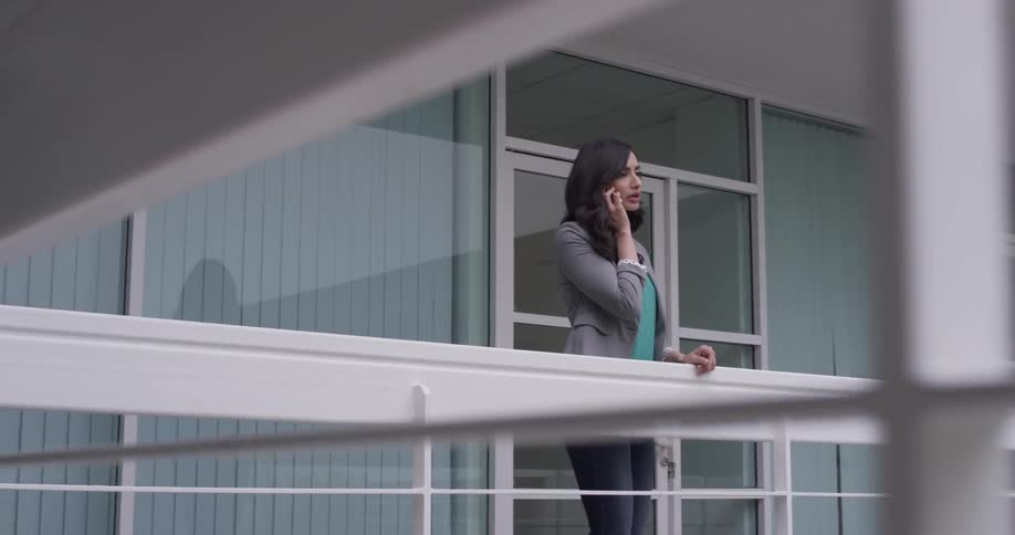 Woman talking on a phone on a balcony