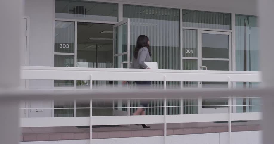 A woman walking out an office to a balcony